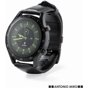 A watch with a black leather strap and a round black face featuring green accents and a logo.