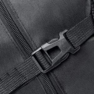 A close-up of a black fabric surface featuring a plastic buckle and zipper detail.