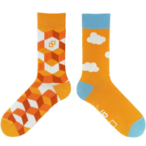 A pair of socks featuring an orange geometric design on one and a cloud pattern on the other, with blue accents.