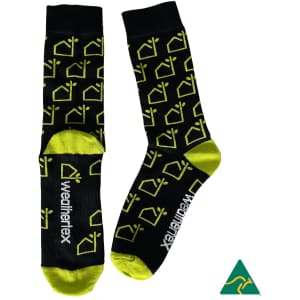 Combed cotton socks in black and lime green featuring a repeated house pattern and a logo.