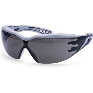 A pair of Dynamic Plus Safety Glasses with a grey frame and dark tinted lenses, featuring a logo on the side.