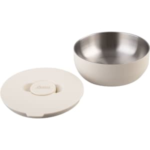 An insulated lunch bowl in cream colour featuring a stainless steel interior and a matching lid. It has a logo.