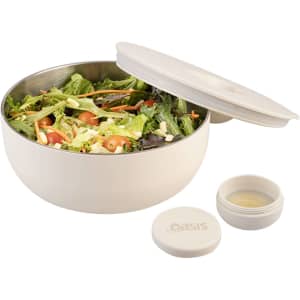 A salad bowl in cream colour with a lid, featuring fresh salad and a small container for dressing. It has a logo.