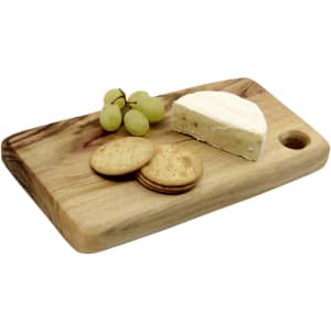 A wooden cheese board featuring a wedge of cheese, crackers, and green grapes. The board has a rounded edge and a hole.