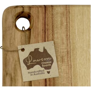 A wooden cheese board with a hole for hanging, featuring a natural finish and a tag with a logo.