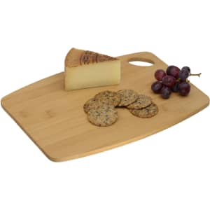 A bamboo cheese board featuring a wedge of cheese, crackers, and a bunch of grapes, with a handle and a logo.