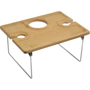 A bamboo picnic table with metal legs, featuring two cup holders and a central circular cutout.
