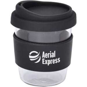 A reusable coffee cup in clear with a black silicone sleeve and a black lid, featuring a logo.