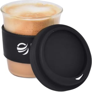 A reusable coffee cup in clear glass, featuring a black silicone sleeve and lid, containing a frothy beverage.