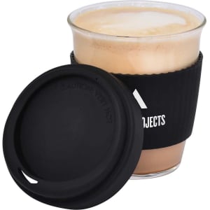 A drink cup featuring a black silicone sleeve and lid, filled with a frothy coffee beverage.