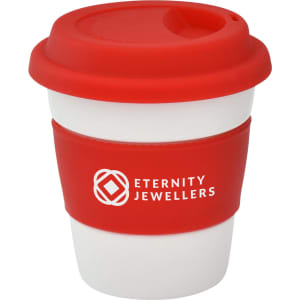 A reusable ceramic coffee mug with a red silicone lid and grip, featuring a logo on the front.