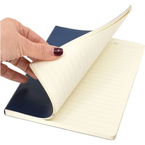 A navy and cream Zenith A5 Notebook, featuring lined pages and a sleek cover design, held open by a hand.