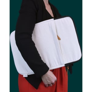 A laptop sleeve in cream with a black zipper, held by a person wearing a black top and red skirt.