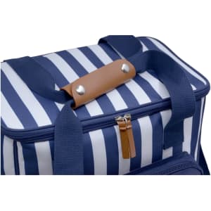 A navy striped cooler bag with a brown leather handle and a zippered closure. It also features sturdy blue straps.