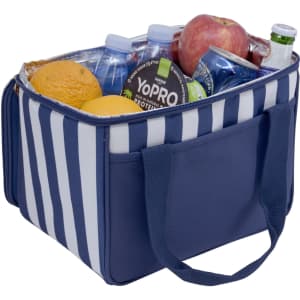 A navy striped cooler bag filled with water bottles, an apple, oranges, and soft drinks, featuring sturdy handles.
