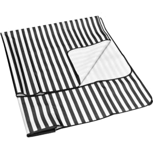 A black and white striped extra-large picnic rug with a corner pocket, featuring a subtle logo.