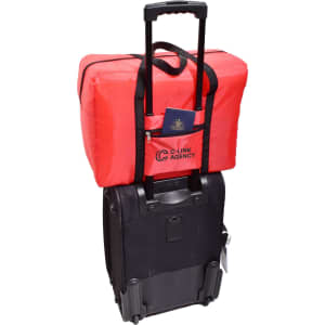 A red insulated bag sits atop a black wheeled suitcase, with a passport visible in the front pocket.