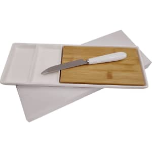 A white serving platter with a bamboo cutting board and a silver knife with a white handle.