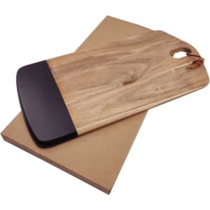 A wooden cheese board with a black edge, resting on a brown cardboard base. Features a handle for easy carrying.