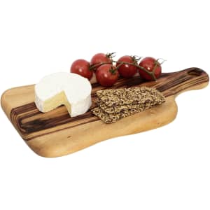 A wooden cheese board with a round cheese, crackers, and a bunch of cherry tomatoes, featuring a branding logo.