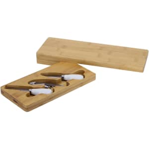 A bamboo cheese board set with white-handled cheese knives, housed in a wooden box.