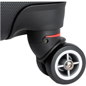 A close-up of a black wheeled suitcase wheel with a grey and white design, featuring a small red accent.