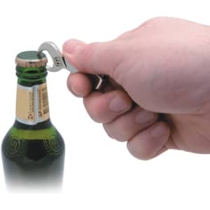 A drink bottle being opened with a silver DIY keyring bottle opener held by a hand. The bottle has a green glass body.