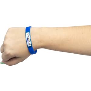A blue silicon wristband on a wrist, featuring a logo on an attached rectangular plaque.