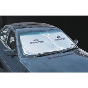 A silver sunshade with circular cutouts is placed on a car's windscreen, featuring a logo.