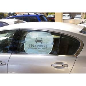 A car window featuring a round sunshade with a graphic of a car and the text "SPINTERN." The shade is white with black details.