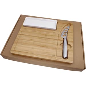 A bamboo cheese board set with a stainless steel knife and a white serving dish in a cardboard box.