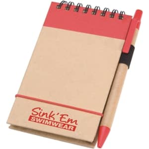 A notepad with a red top, brown cover, and a pen attached via an elastic band. It features a logo on the cover.
