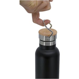 A drink bottle featuring a black body, stainless steel lid, and a wooden top, held by a hand.