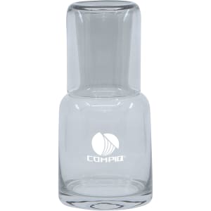 A clear glass carafe with a tumbler base, featuring a logo. Simple, elegant design in transparent glass.