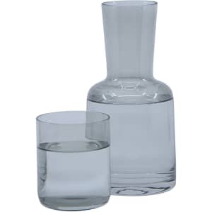 A clear glass carafe and tumbler set filled with water, featuring a simple, elegant design.