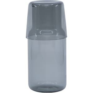 A grey glass carafe with a matching tumbler on top, featuring a simple and sleek design.