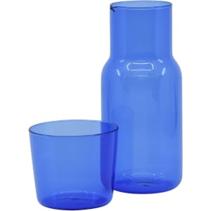 A blue glass carafe with a matching tumbler, featuring a simple design and a logo on the surface.