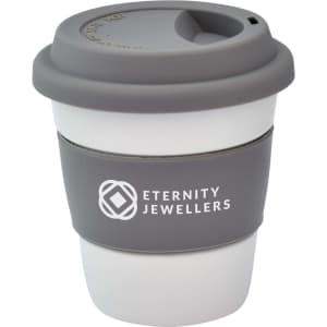 A reusable ceramic mug in white and grey, featuring a silicone lid and grip band, with a logo on the side.