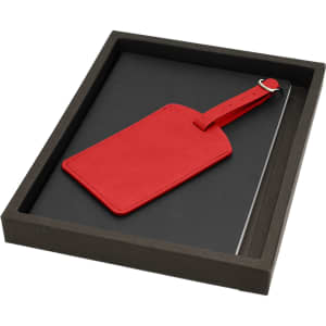 A red luggage tag and a notebook set in a black presentation box. The box has a plain exterior with no branding.