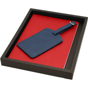 A red notebook and a navy blue luggage tag presented in a black gift box.