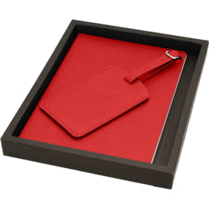 A red travel journal accompanied by a matching luggage tag, presented in a black box.