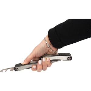 A stainless steel multi-tool held in a hand, featuring various tools and a silver chain bracelet.