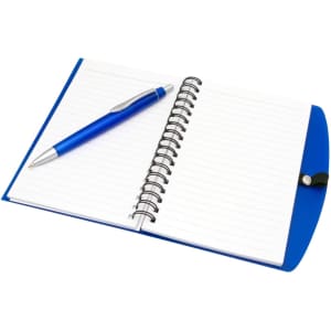 A blue notepad with lined pages and a silver pen resting on top. The notepad features a spiral binding.