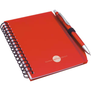 A red notepad with a spiral binding and a matching red pen, featuring a logo on the front cover.