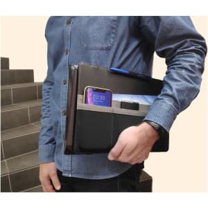 A black laptop bag is held by a person, featuring compartments for a phone, pen, and tablet. The bag has a logo.