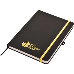 A black A5 notepad with a gold elastic band and a logo on the cover.