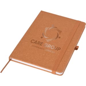 A brown A5 notebook with a textured cover and an elastic band, featuring a logo on the front.