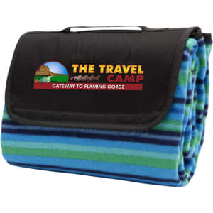 A blue and green striped picnic rug featuring a black fold-over flap with a logo. Ideal for outdoor leisure activities.
