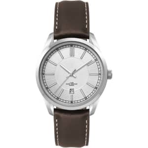A silver watch with a minimalist face and a brown leather strap, featuring a logo on the dial.