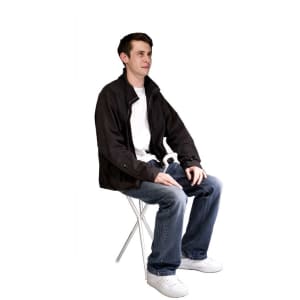 A compact folding chair in white with a person seated, wearing casual attire and a black jacket.